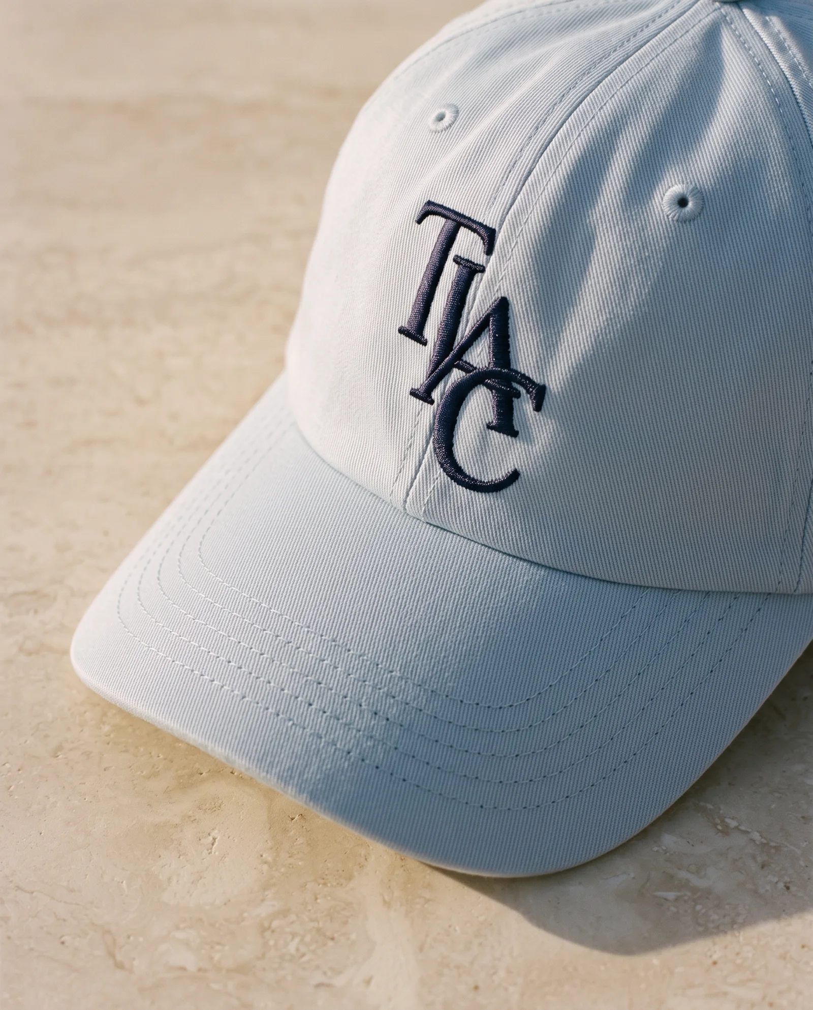 TIAC structured cap monogram and stitching detail